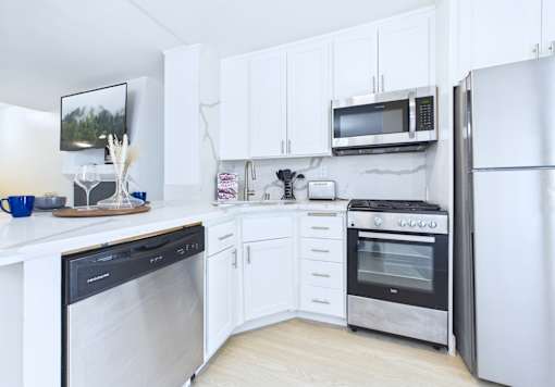 A kitchen with white cabinets and appliances.