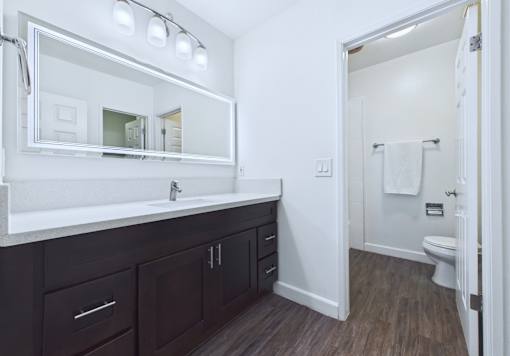 A bathroom with a white sink and a mirror above it.