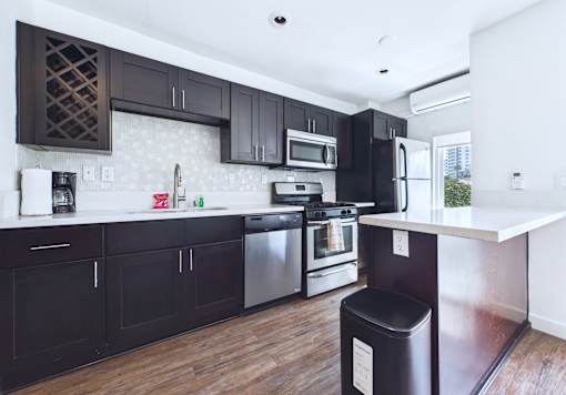 A kitchen with dark brown cabinets and stainless steel appliances.