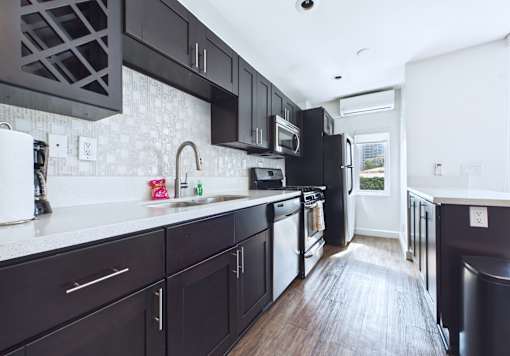 A kitchen with black cabinets and a white counter.