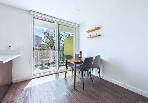 A dining room with a table and chairs and a sliding glass door.