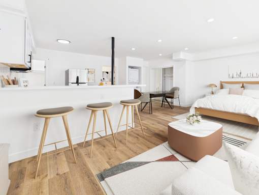 A modern living room with a kitchen area in the background.