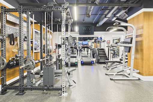 A gym with a variety of equipment including weights and cardio machines.