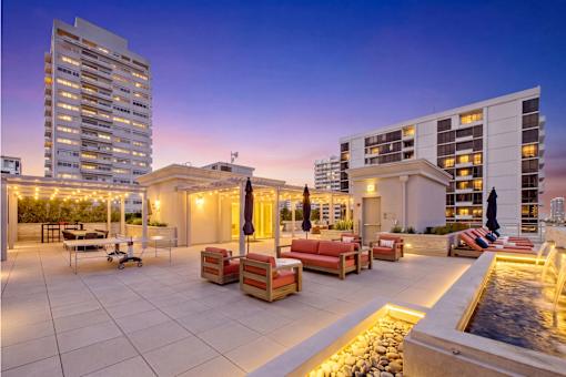 A rooftop patio with a fountain and seating area.