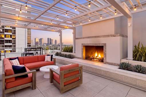 A patio with a fireplace and a view of the city.