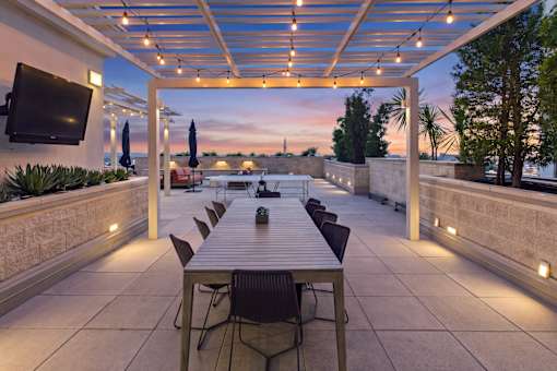 A patio with a table and chairs under a roof.