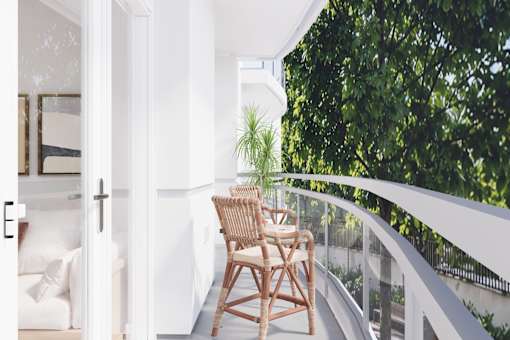 A wooden chair is on a balcony with a white railing.