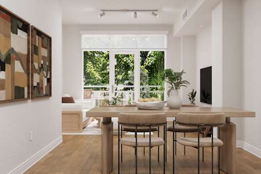 A dining room with a table and chairs and a painting on the wall.