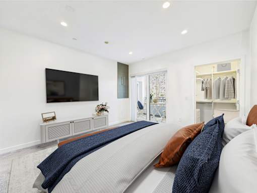 A modern living room with a grey sofa and a flat screen TV mounted on the wall.
