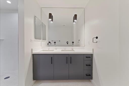 A bathroom with a sink, mirror, and cabinets.