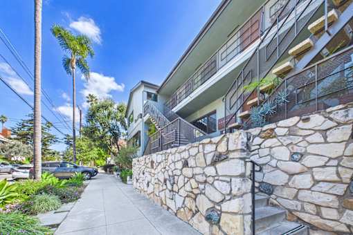 A stone wall runs along the side of a building.