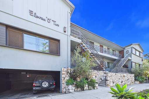 A car is parked in a garage under a building with the sign "Ellevue O'Two".