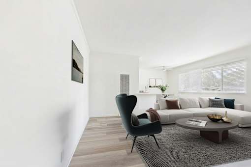 A modern living room with a black chair and a grey coffee table.