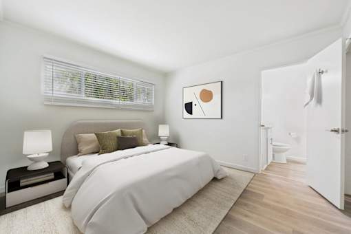 A bedroom with a large bed and a painting on the wall.