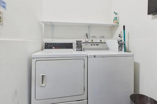 A white cabinet with a door and a drawer is in a room.