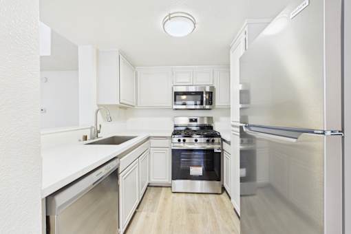 A modern kitchen with stainless steel appliances and white cabinetry.