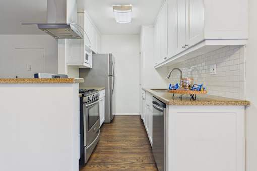 A kitchen with white cabinets and stainless steel appliances.