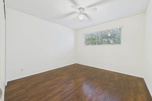 A room with a wooden floor and a ceiling fan.