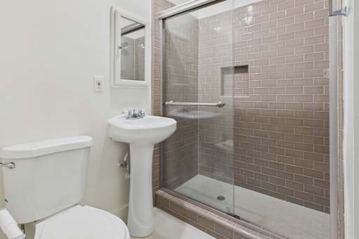 A white toilet sits next to a white sink in a bathroom.