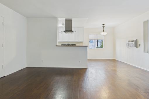 A large empty room with wooden floors and white walls.