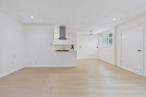 A spacious kitchen with a stove top oven and a window.