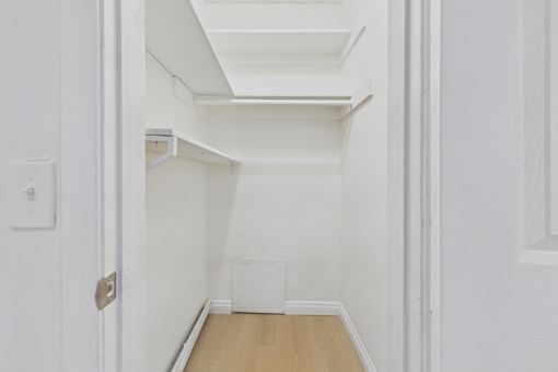 A white hallway with a door on the left and a skylight above.