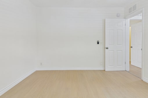 A room with a white door and a white wall.