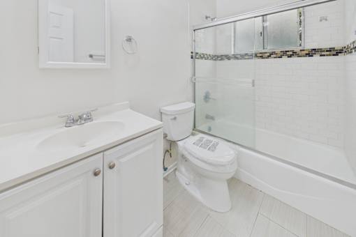 A white toilet is in a bathroom with a glass shower door.