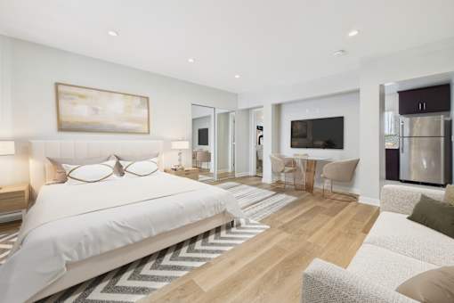 A bedroom with a large bed and a painting on the wall.