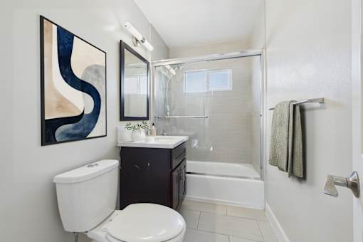 A bathroom with a toilet, sink, and shower.