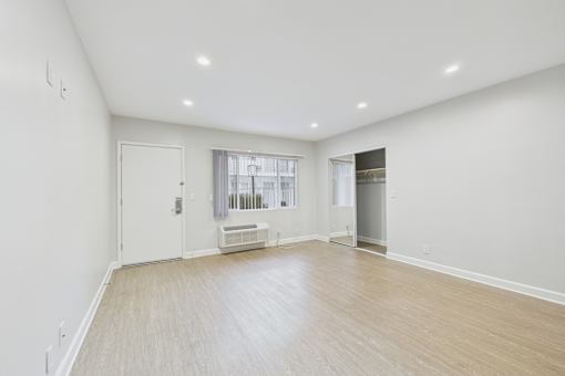 A spacious room with a window and a door.