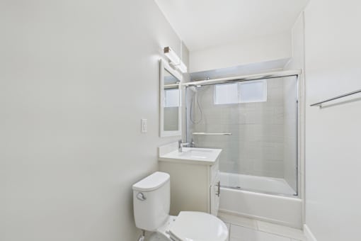 A white toilet sits next to a sink in a small bathroom.