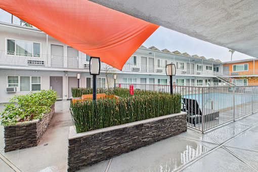 A building with a pool and a red tarp covering the area.
