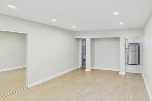 A spacious room with a door and a trash can.