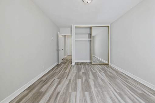 A room with a white door and a grey floor.