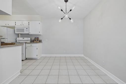 A kitchen with white appliances and a white ceiling.