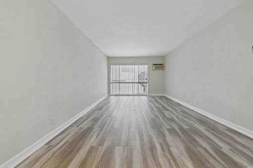 A room with wooden flooring and white walls.