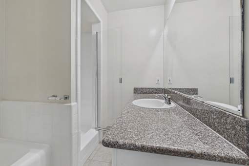 A bathroom with a white tub and sink.