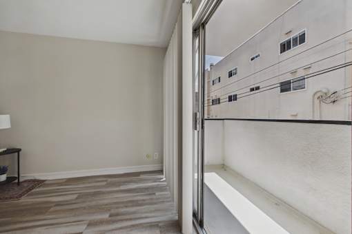 A room with a wooden floor and a wall with a window.