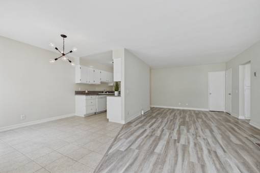 A spacious room with a kitchen area and a dining table.