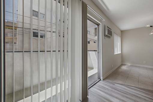 A room with a sliding glass door leading to a balcony.