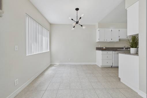 A kitchen with white cabinets and a ceiling fan.