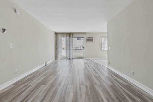A room with a wooden floor and a white door.