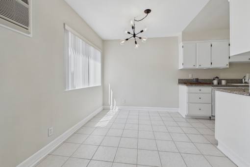 A kitchen with white cabinets and a white ceiling fan.