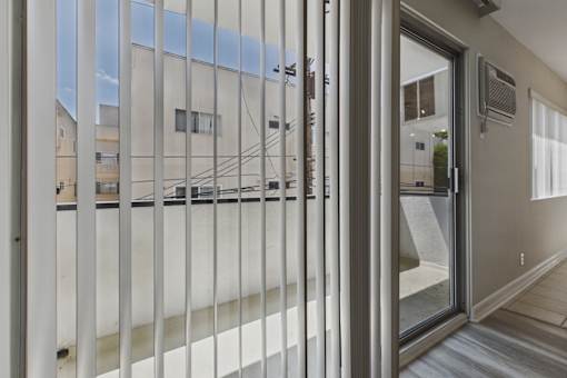 A view through a window into a room with a sliding glass door.
