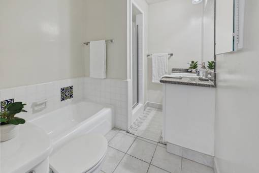 A white bathroom with a tub, toilet, and sink.