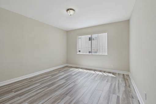 A room with a window and wooden flooring.