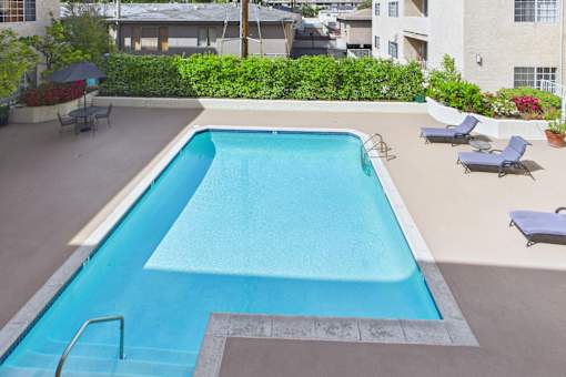 A rectangular pool with a metal ladder on the side.