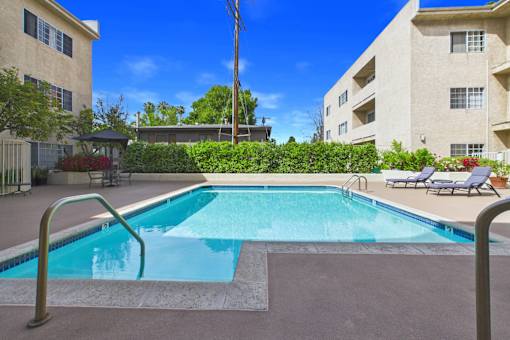 A swimming pool surrounded by a metal railing and a concrete floor.