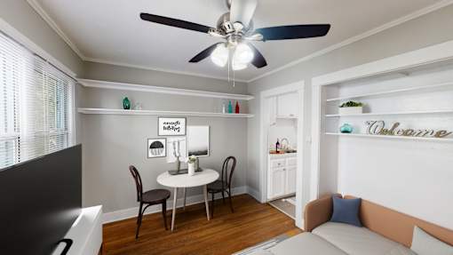 A living room with a dining table and chairs.